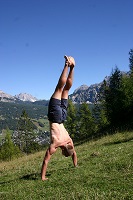 Cortina, Italy - Performing a handstand on a ski slope over Cortina
